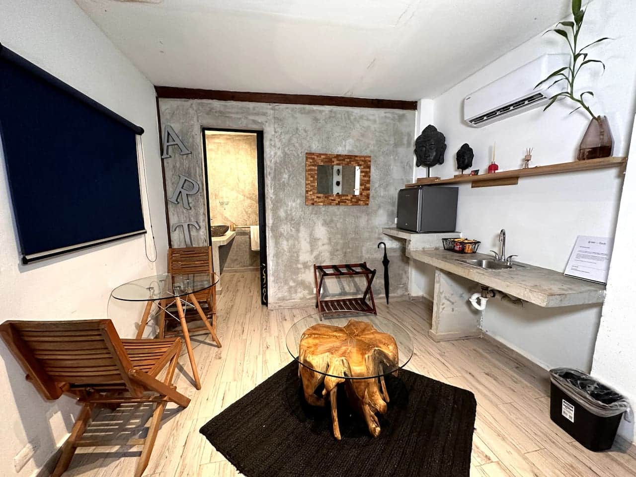 Wide view of a suite with textured walls, wood-look floors and a bistro table, Saboga Lodge