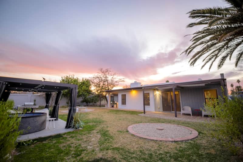 Private backyard at sunset, with a hot tub, covered patios and space to unwind.