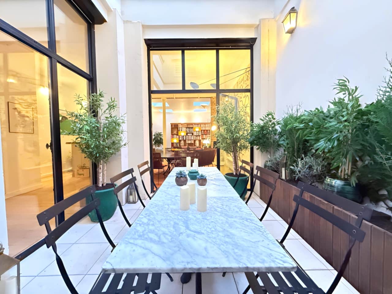 2 SPARIS – Patio extérieur avec ses tables bistrot et une ambiance verdoyante