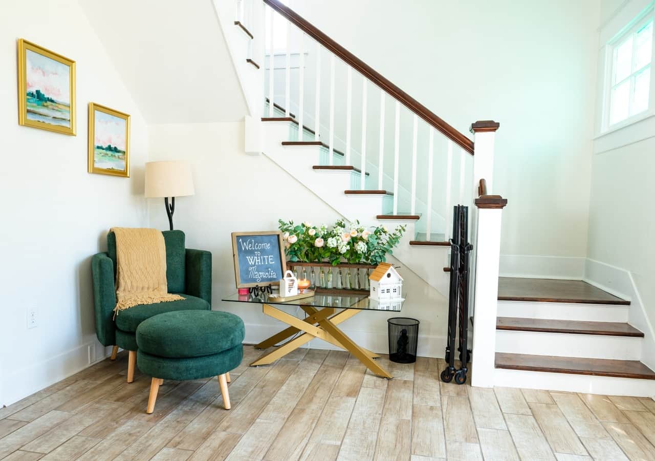 Cozy lounge area with green plush chair and flower details.