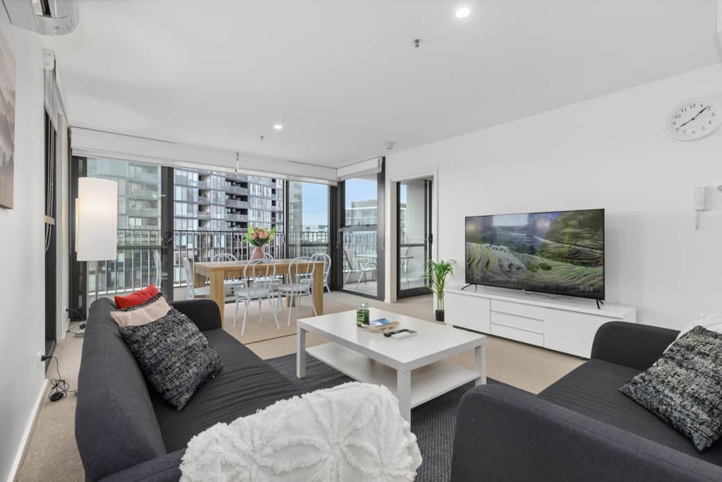 Our modern living room bathed in natural light from the grand windows. The  dark sofas and the white coffee table create a chic welcoming atmosphere. With a favorite show on the large flat-screen TV or simply enjoy the city's rhythm .