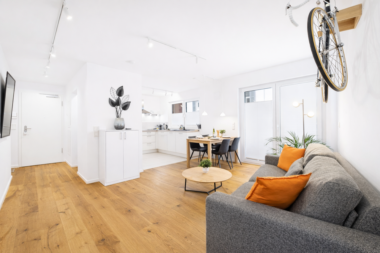 Open living and dining area with a modern kitchen. Spacious, light-filled room.