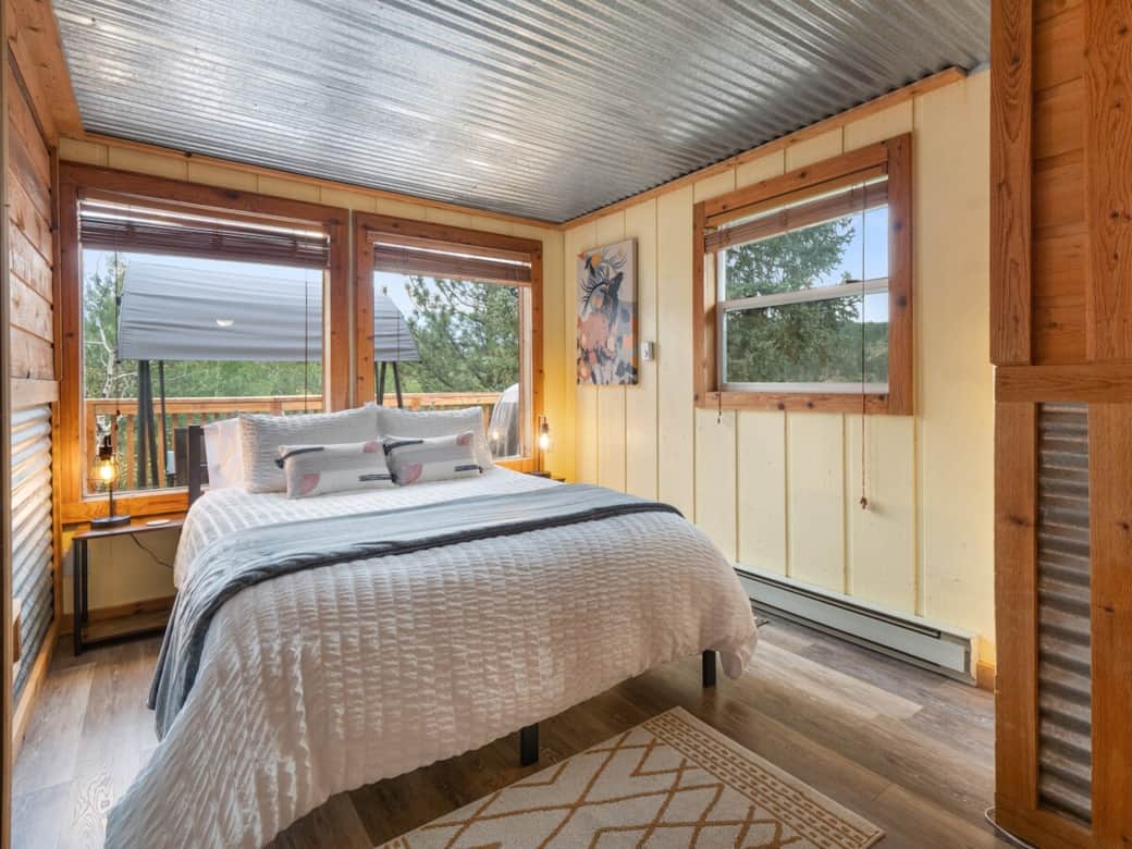 Main level bedroom with USB nightstands and comfy sheets and pillows and room darkening blinds.