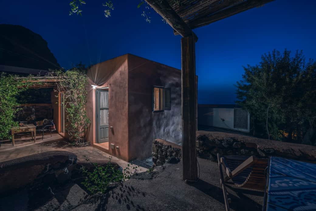 Casetta rosa a Pollara di notte: atmosfera intima e silenzio nella natura di Salina.