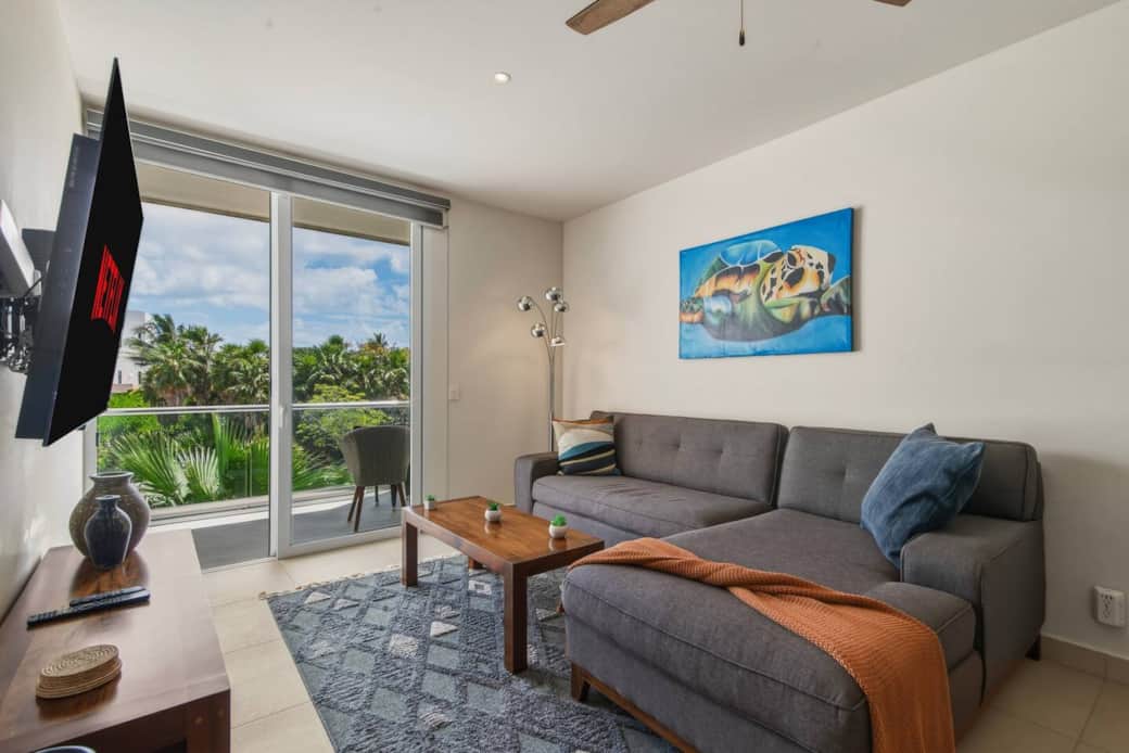 Unwind in a bright, cozy living room with a comfy couch and 55” smart TV. Step onto your private balcony with a slight view of the Akumal sea, and enjoy A/C, a ceiling fan, and room-darkening shades for total comfort. Unwind in a bright, cozy living room with a comfy couch and 55” smart TV. Step onto your private balcony with a slight view of the Akumal sea, and enjoy A/C, a ceiling fan, and room-darkening shades for total comfort.