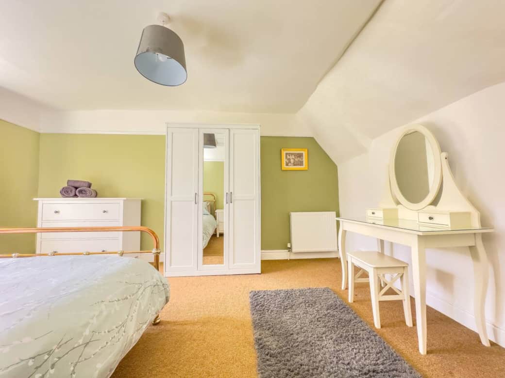 Master bedroom with kingsize bed, dressing table, wardrobe and chest of drawers