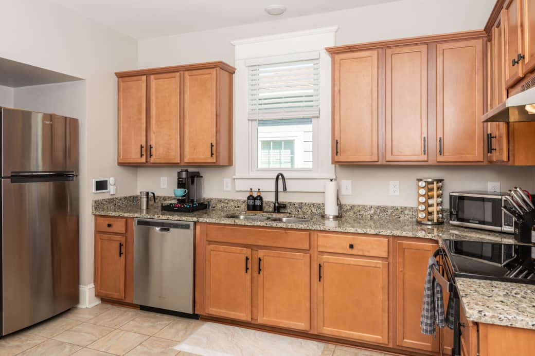 Full Size Kitchen with fridge, dishwasher, stove, oven, microwave, and coffee machine.