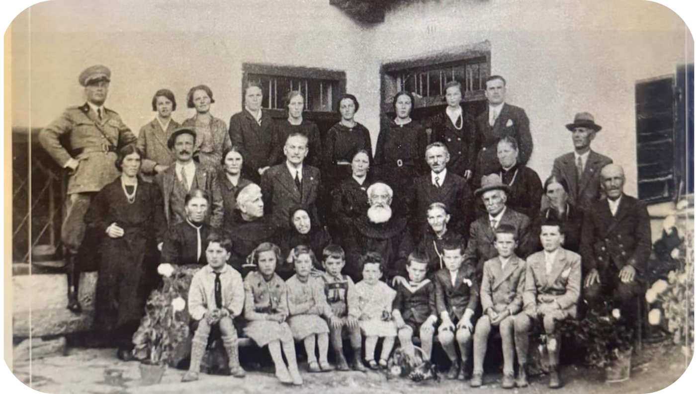 Historic photograph of Antonio, known as Tone, with his family outside Ciasa de Tòful