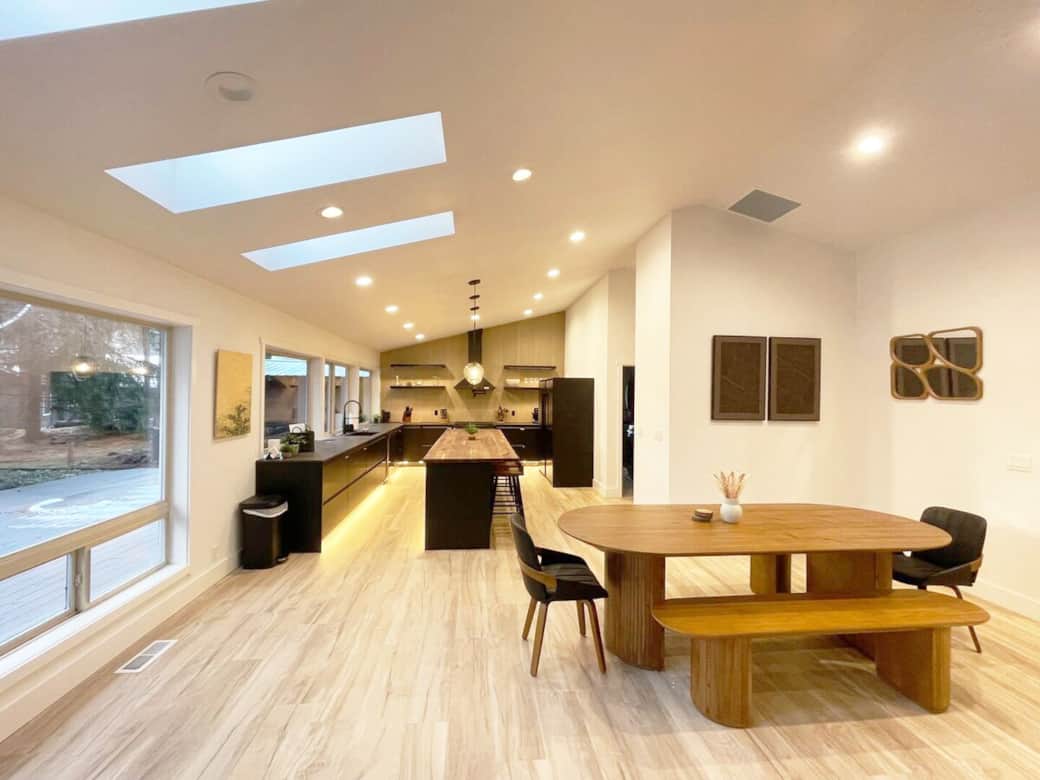 Bright and airy dining area illuminated by ample skylights.