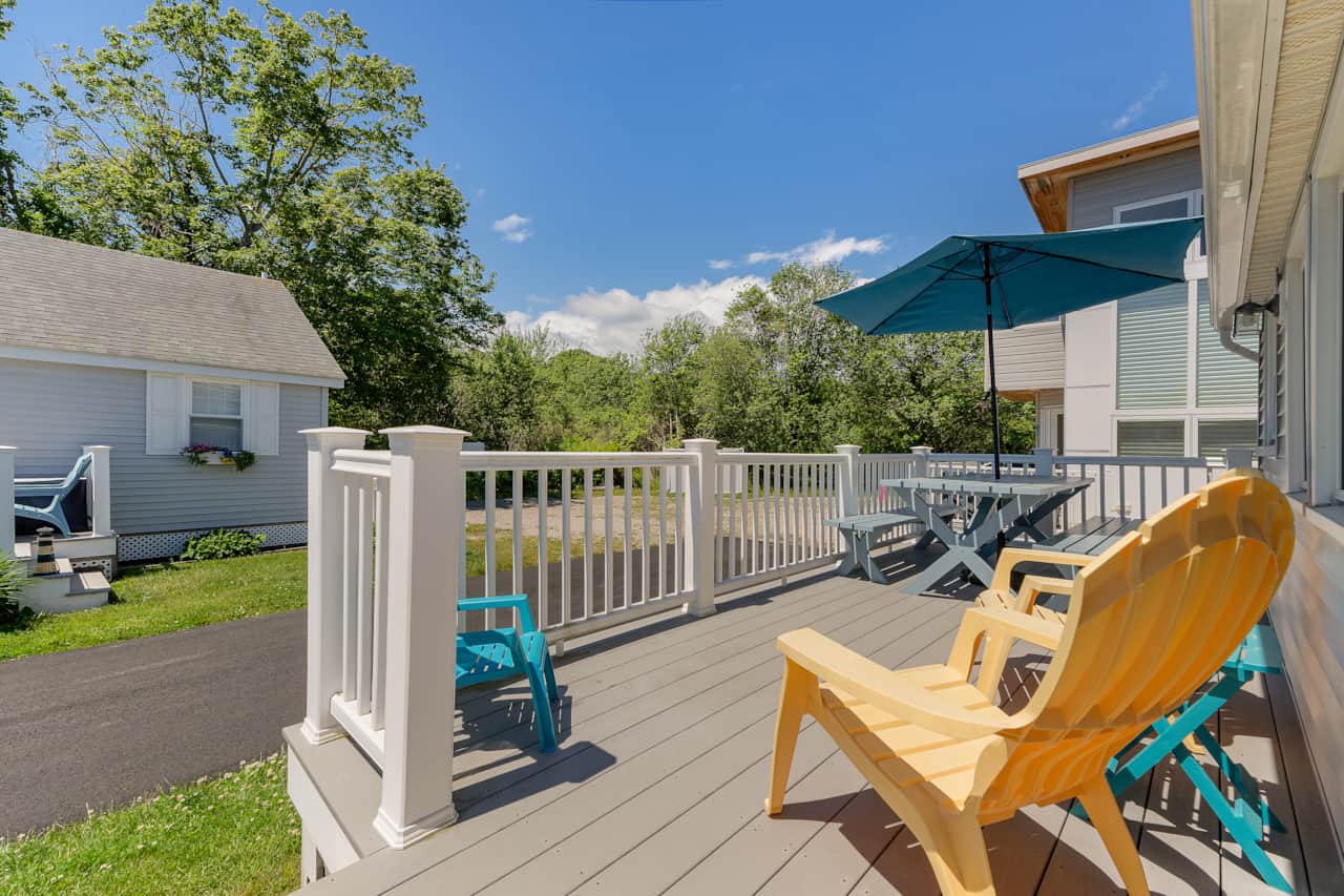 Great porch with table, umbrella, and chairs