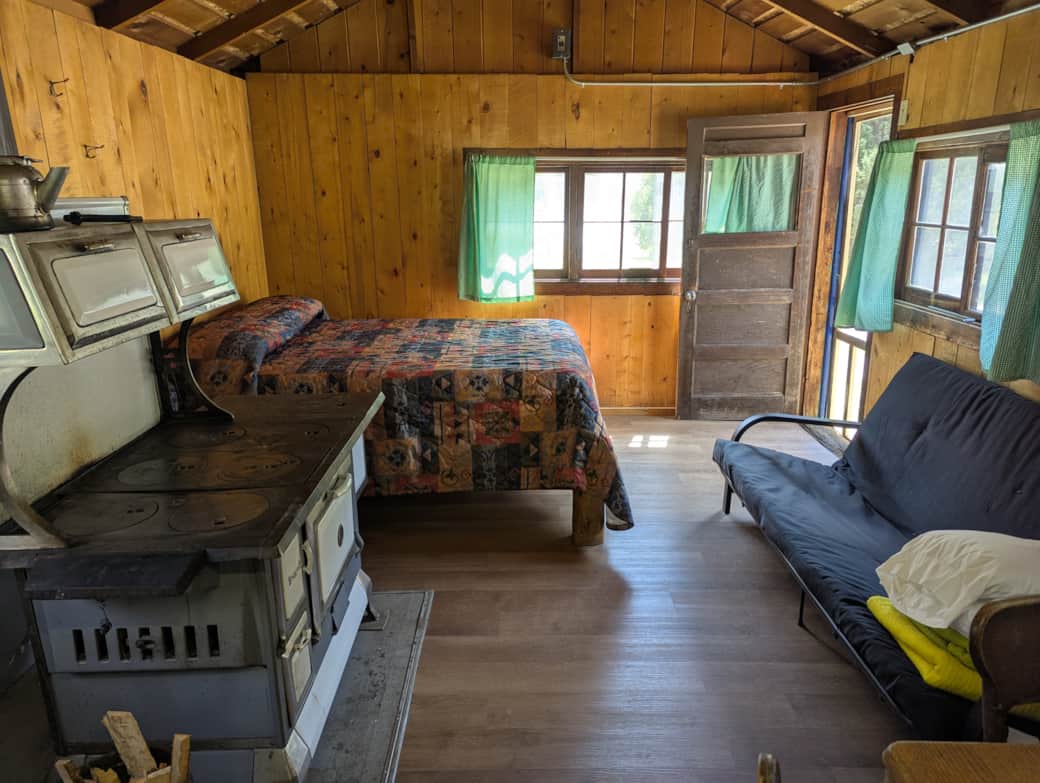 Cabin 3 is a cozy rustic cabin that features a wood-burning stove, two full size beds, and a futon.
