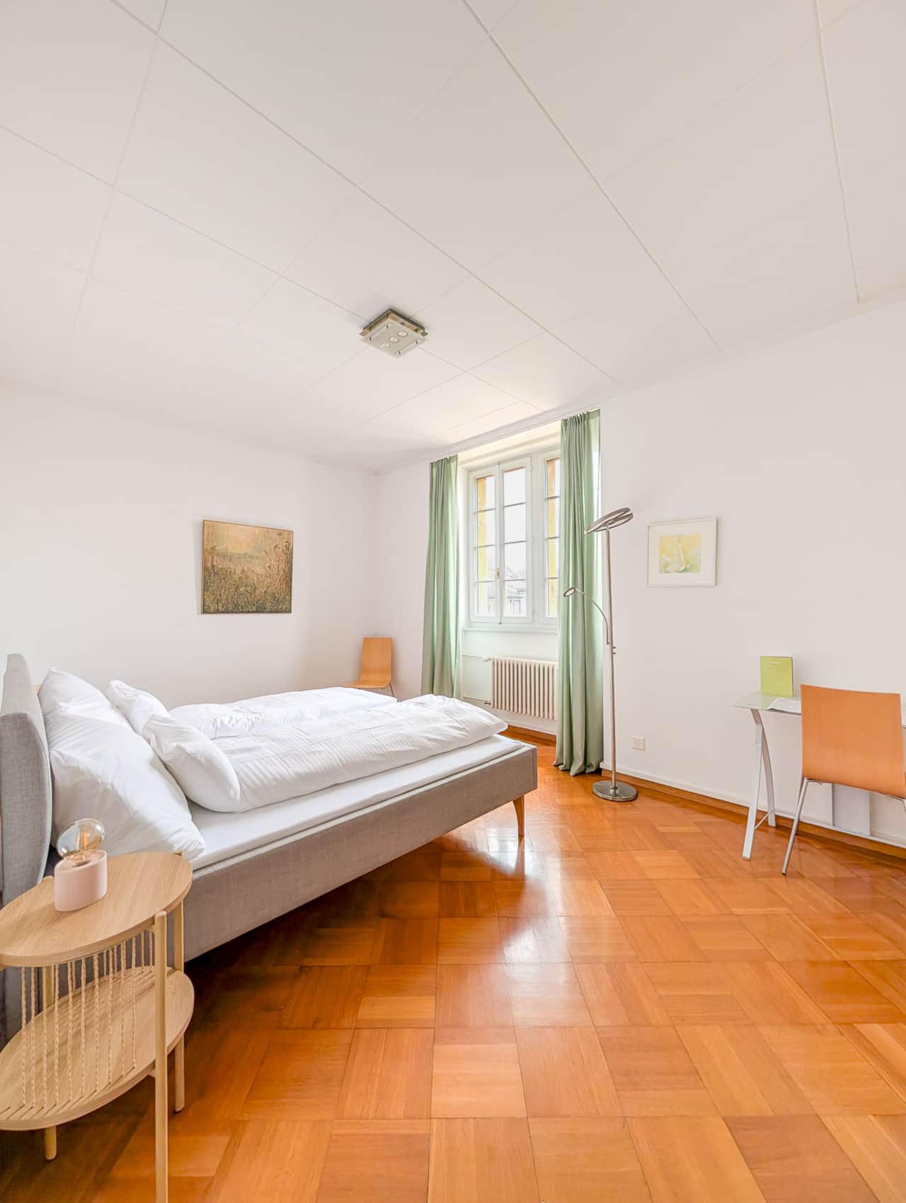 Spacious room with double bed and desk area.