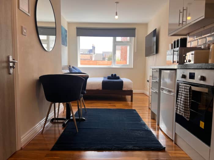 Stylish studio with a desk, kitchen and bed by the window