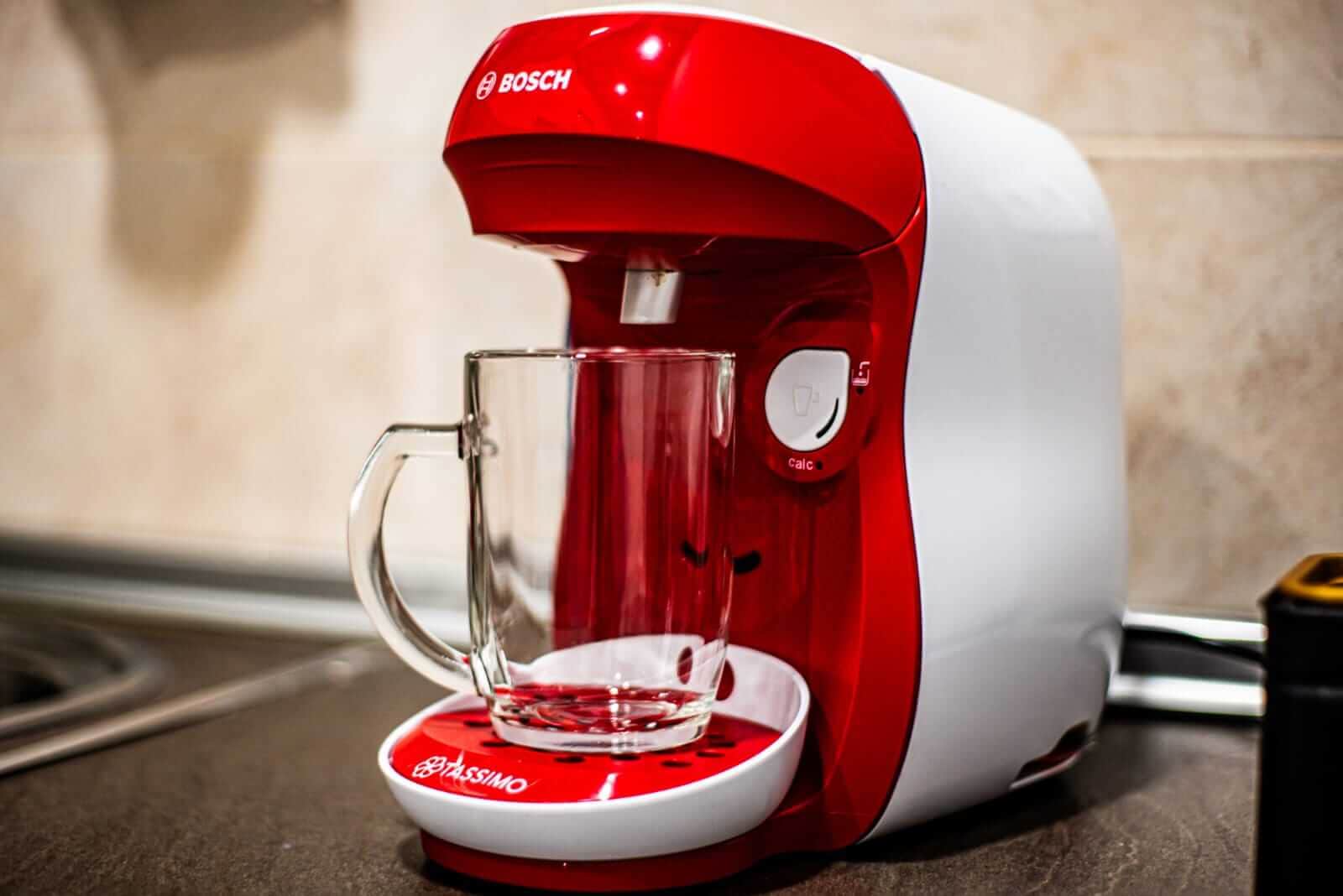 Cafetera Tassimo Bosch en funcionamiento con taza de cristal, detalle de cocina equipada en La Casita de Ale