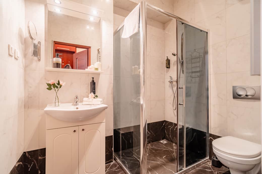 The bathroom is finished with elegant marble tiles and features a shower enclosure.