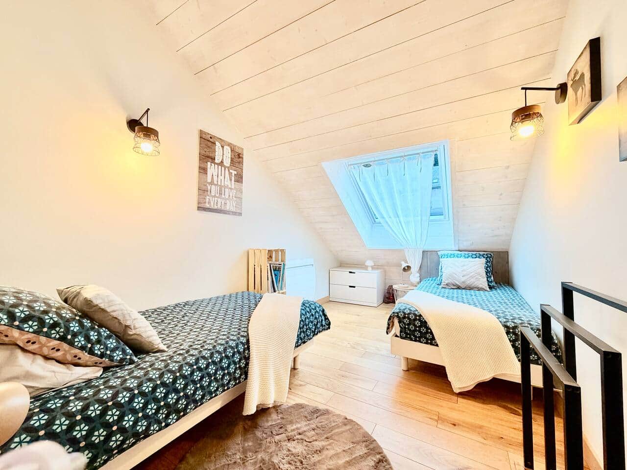 Chambre enfants chaleureuse avec deux lits simples dans l'appartement Le Nid au Mont-Dore.