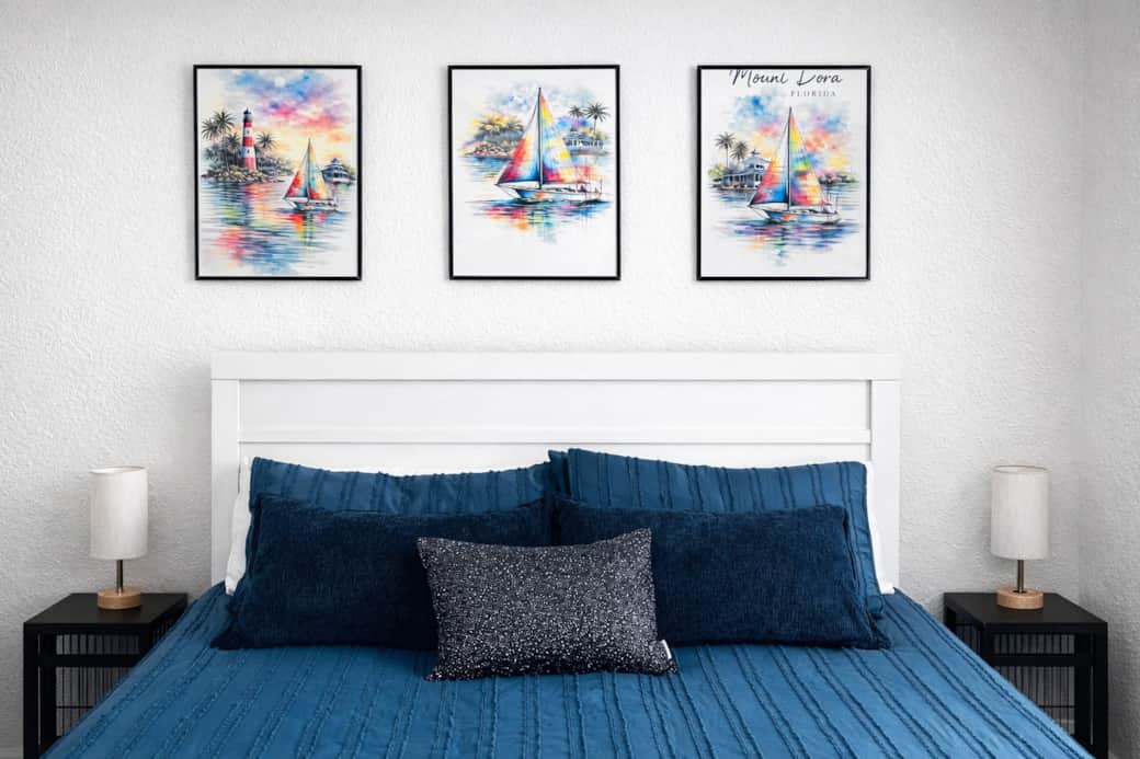 Bright, inviting bedroom with plush blue bedding, vibrant artwork, and a relaxing atmosphere .