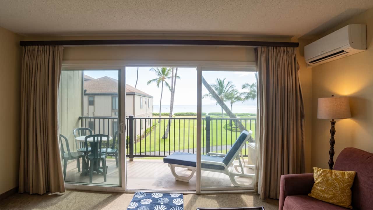 Bright living room with A/C, lanai access, and peaceful ocean views just outside.