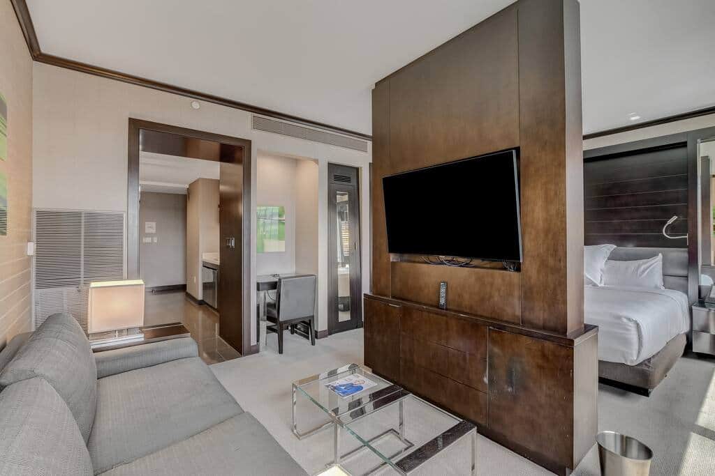Living Area with Sofa, Wall-Mounted TV and City Views