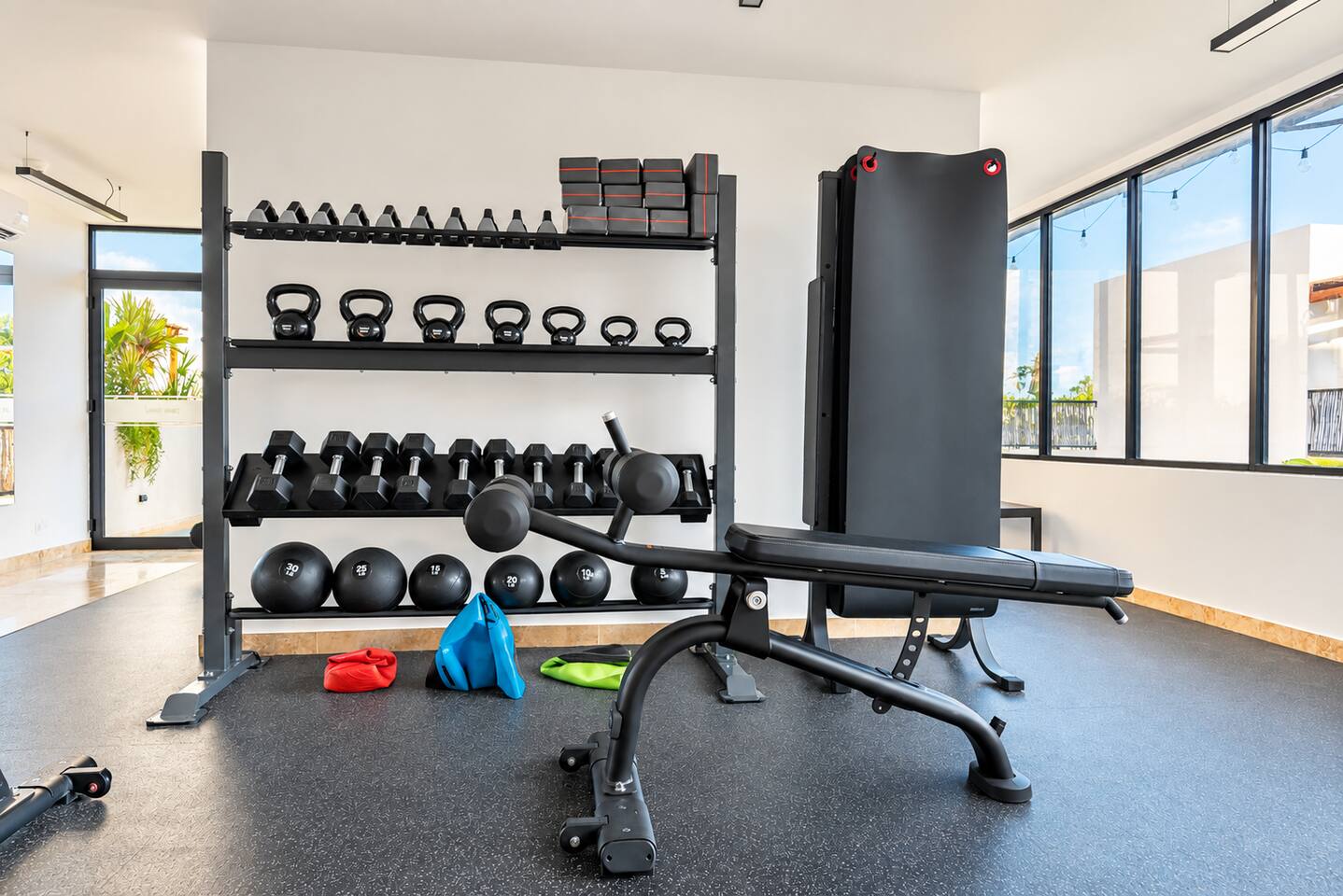 El gimnasio cuenta con mancuernas y pesas libres, e incluye caminadoras, 2 bicicletas fijas, pesas rusas, balones medicinales, bancos de pesas, equipo de fuerza, máquina de poleas, tapetes de yoga y costal de box con guantes para un entrenamiento completo.