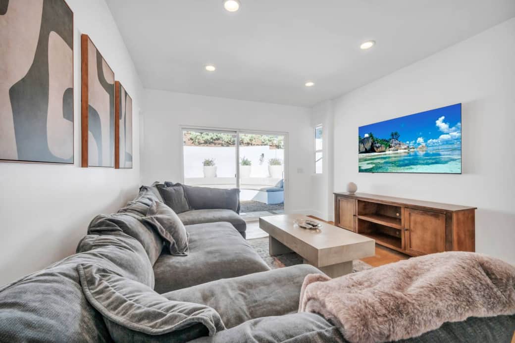 Movie room with sectional seating, wall-mounted TV, and sliding door access to patio Movie room with sectional seating, wall-mounted TV, and sliding door access to patio