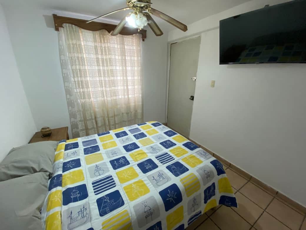 Recamara principal de SMARTSTAY con pantalla de 43"  Smart. cuanta con ventilador de techo, una habitacion muy comoda.