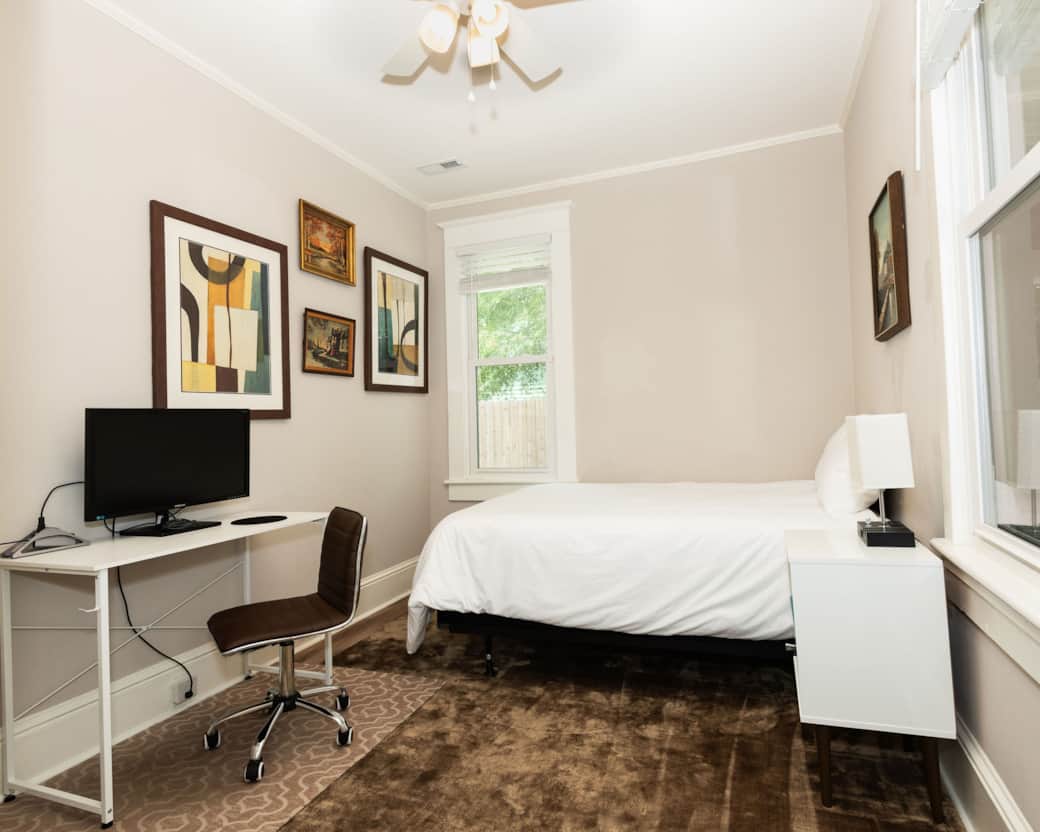 2nd bedroom with a full size bed, ceiling fan, desk, monitor, and dock. 