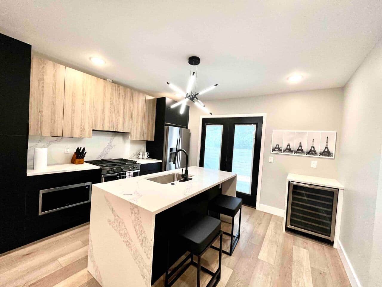 The kitchen boasts a stunning quartz island and is equipped with a 36-inch refrigerator, a professional-grade oven, a dishwasher, a microwave, and a wine bar. Additionally, it offers convenient access to the backyard, perfect for outdoor dining.