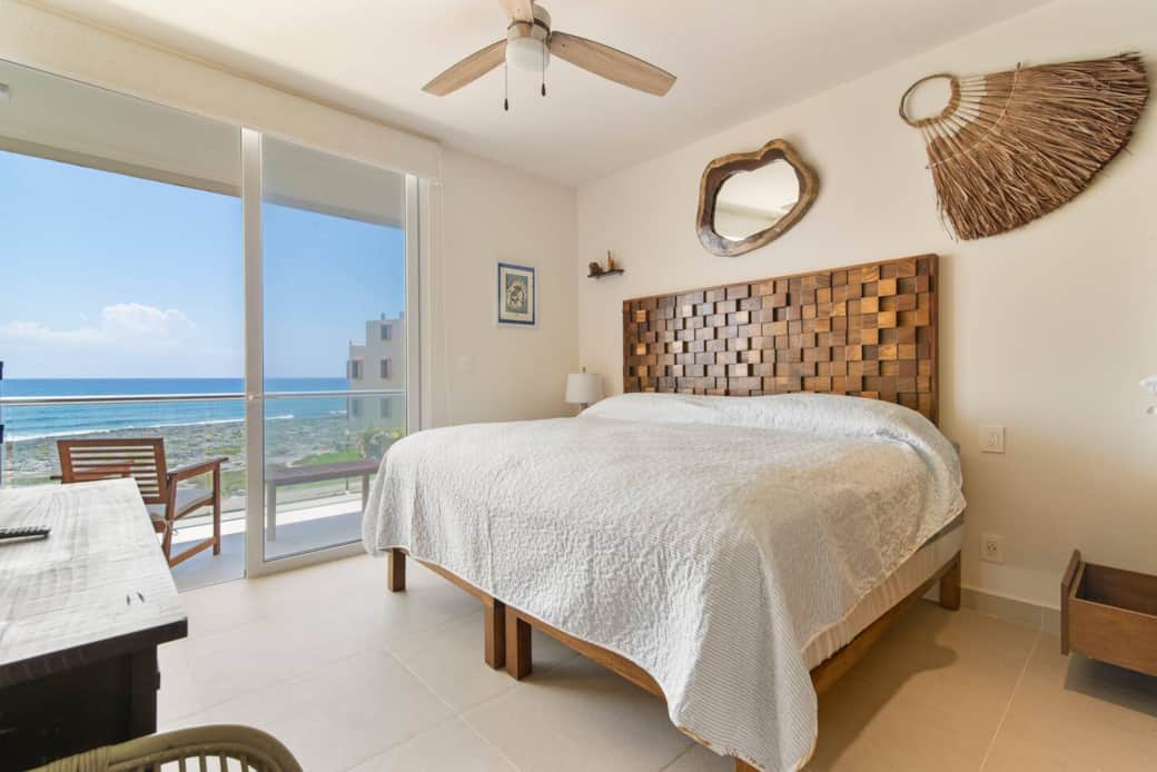 Serene master with king bed, blackout shades, balcony, and Caribbean views.