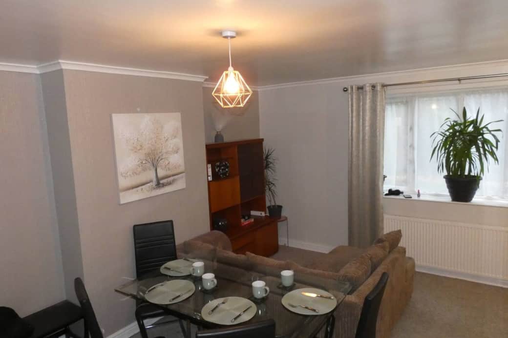 Living room with trundle bed, dining area, sofa and smart TV with wireless mobile screen sharing