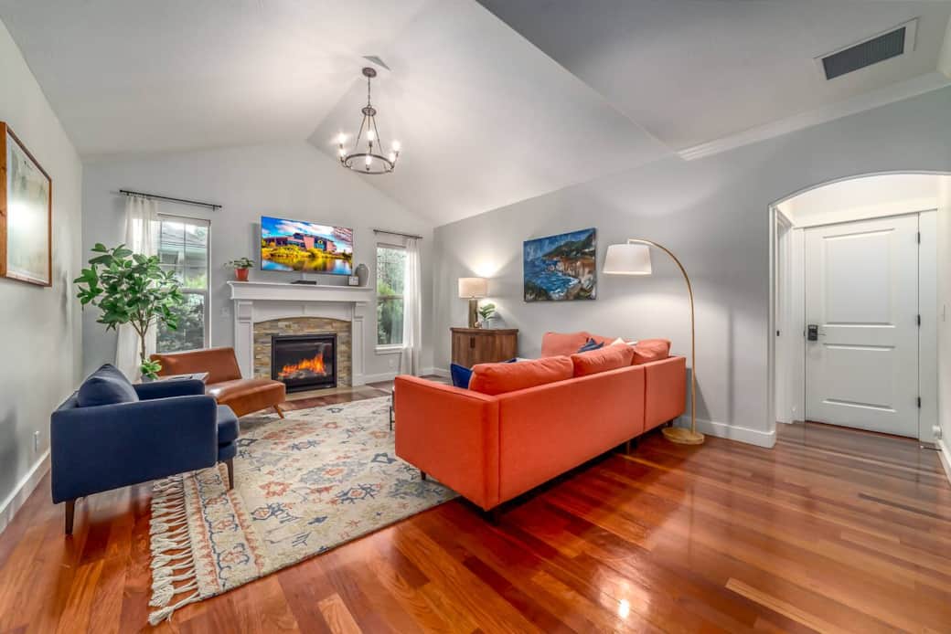 Living room with sectional couch and chairs. Hutch has board games and cards. Gas fireplace and 55" cable TV