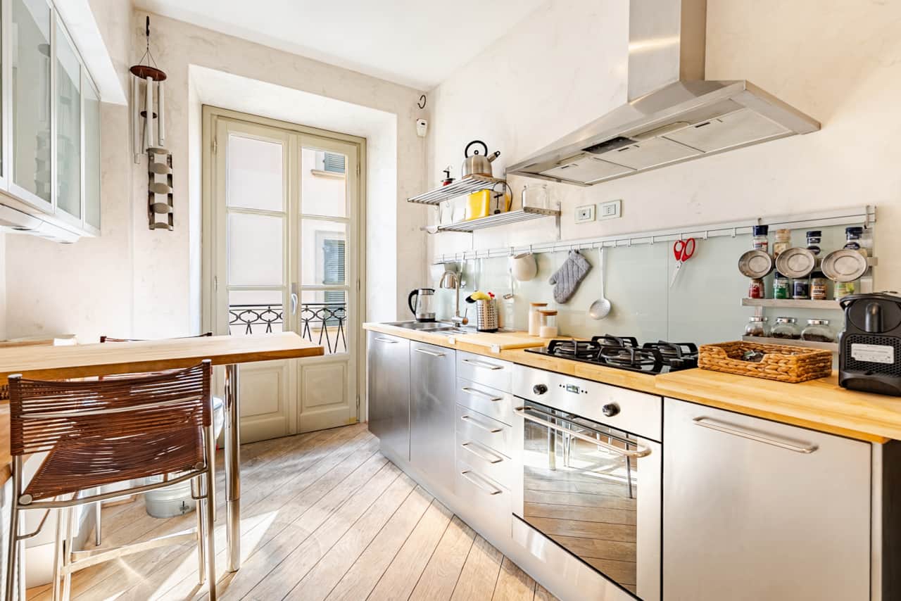 Cucina in acciaio con piano cottura e finestra sui tetti
