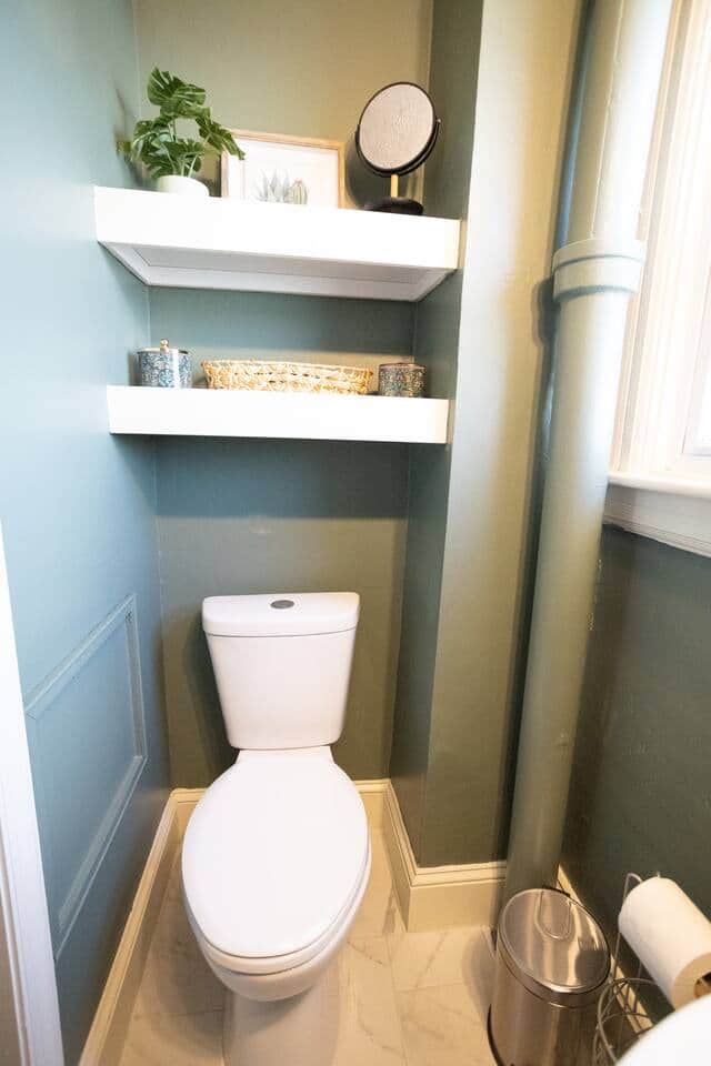 Stylish floating shelves and decorative accents bring warmth to this spotless bathroom, offering practical storage and a touch of charm.