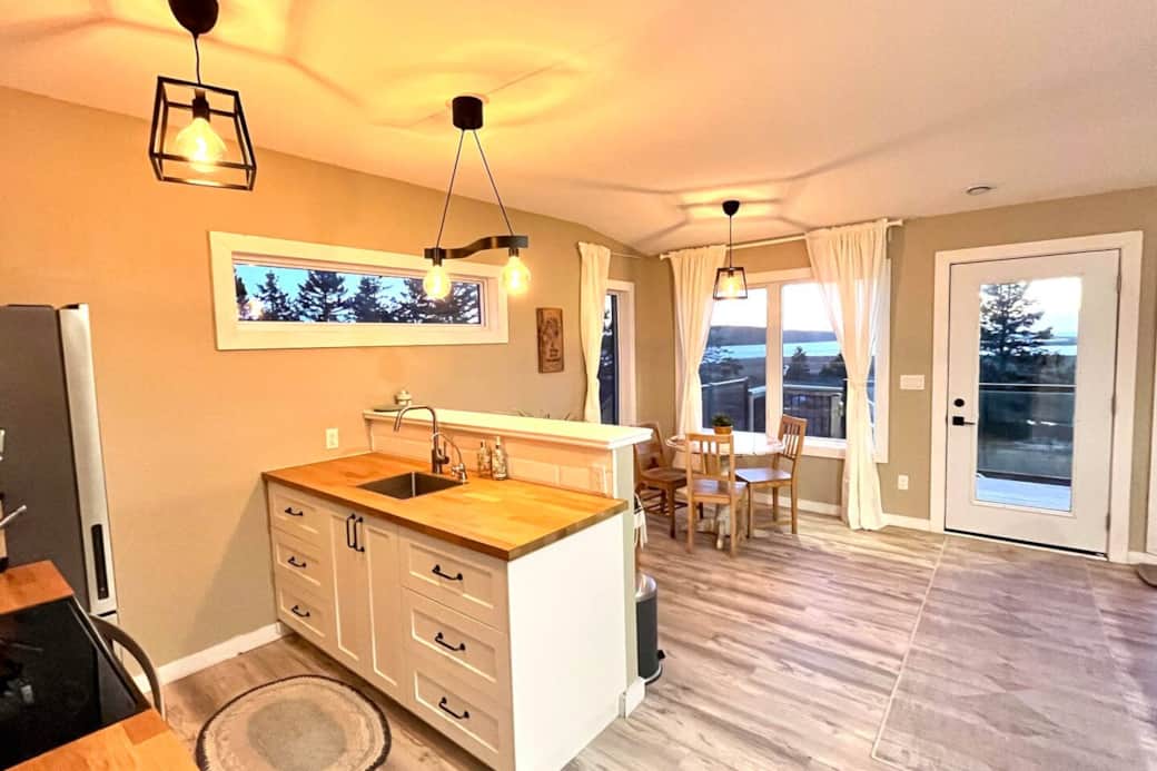 Bright open kitchen-dining with deck access and sunset tree views Bright open kitchen-dining with deck access and sunset tree views