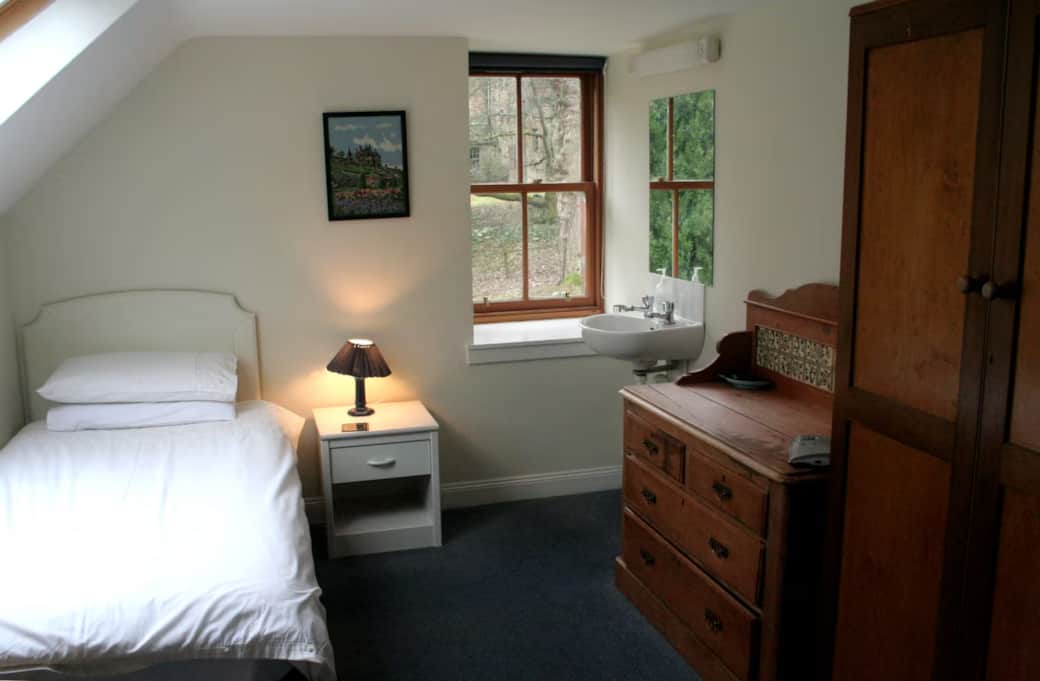 Twin bedroom - a rectangular room with two single beds. One window looking out onto the garden and t Twin bedroom - a rectangular room with two single beds. One window looking out onto the garden and t
