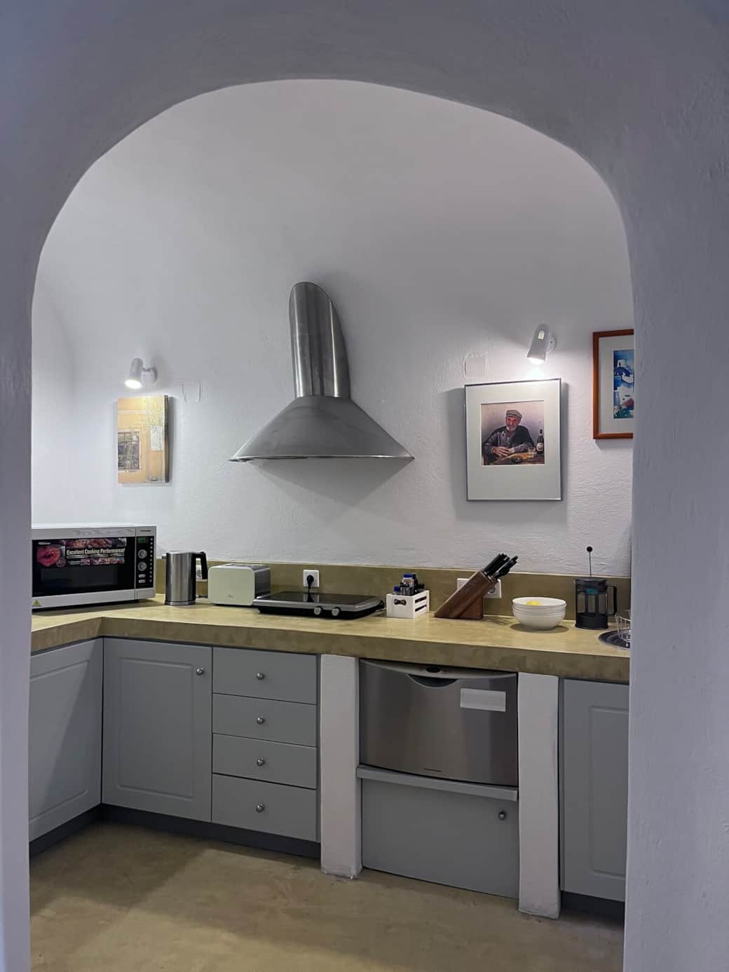 Minimal Santorini kitchen with full appliances and cooking space.