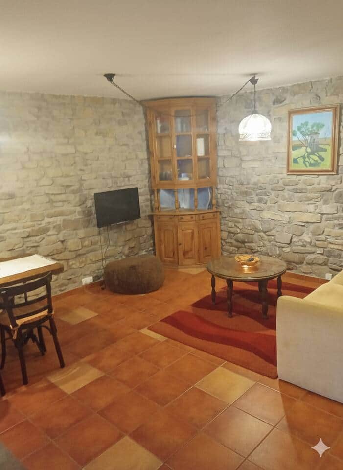 Salón con pared de piedra y TV Salón con pared de piedra y TV