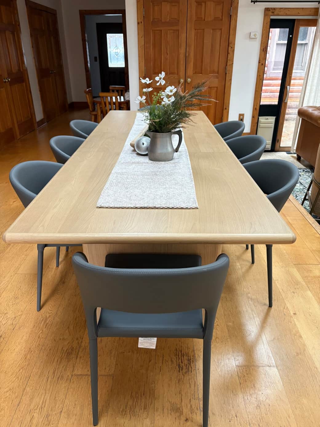 Spacious dining table with modern seating, perfect for shared meals and gatherings, located just off the living area and near the outdoor deck.