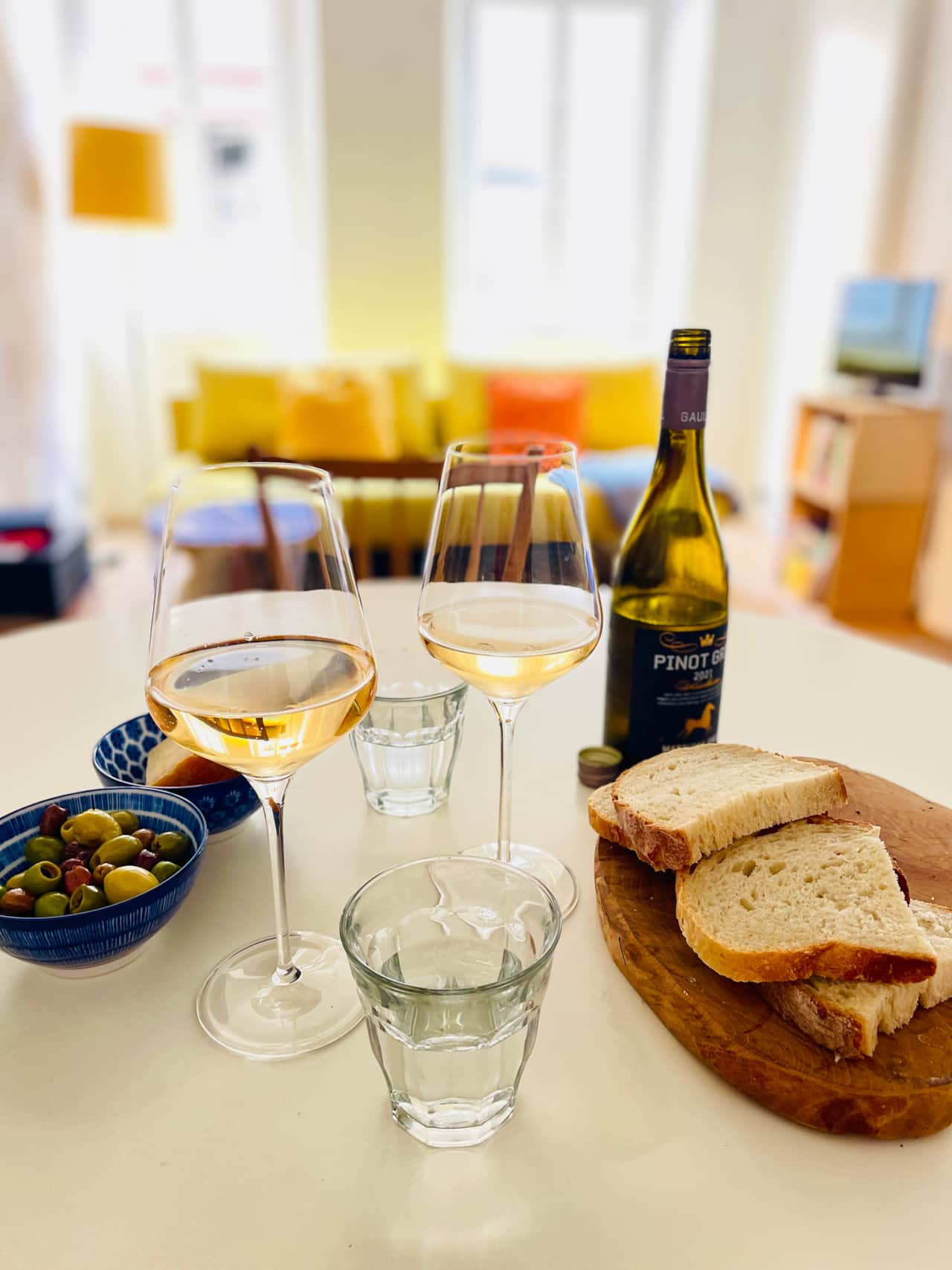 Kleiner Snack mit Brot, Käse und Wein im lichtdurchfluteten Esszimmer