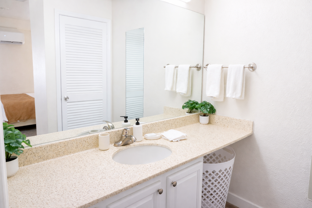 Bright, minimalist bathroom featuring a  tub and all the essentials thoughtfully stocked.