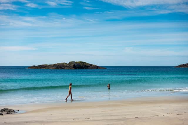 A sandy beach on Mull with turquoise water and rocky islets offshore