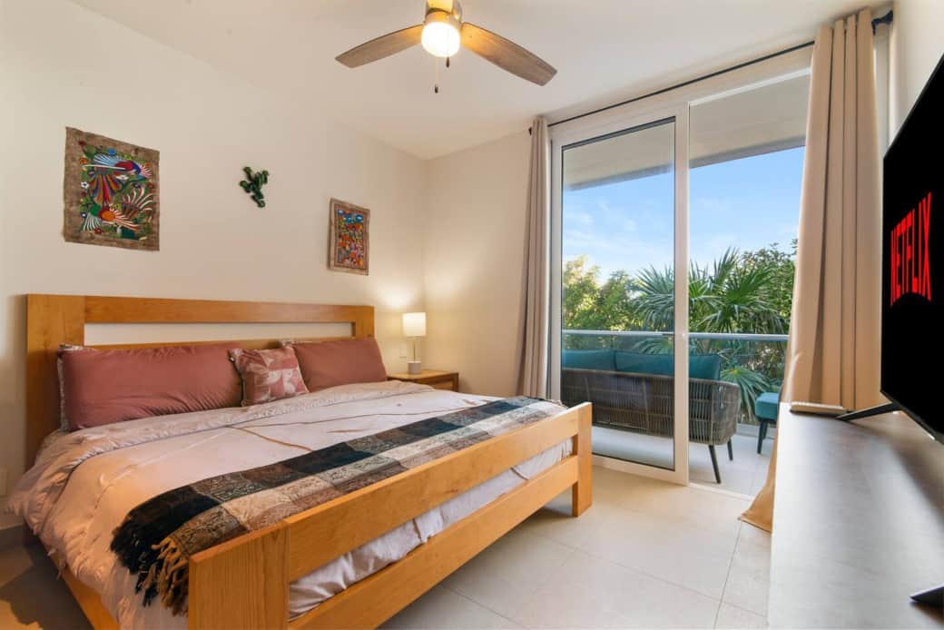 Unwind in the master bedroom with a king bed, AC, TV, and balcony.