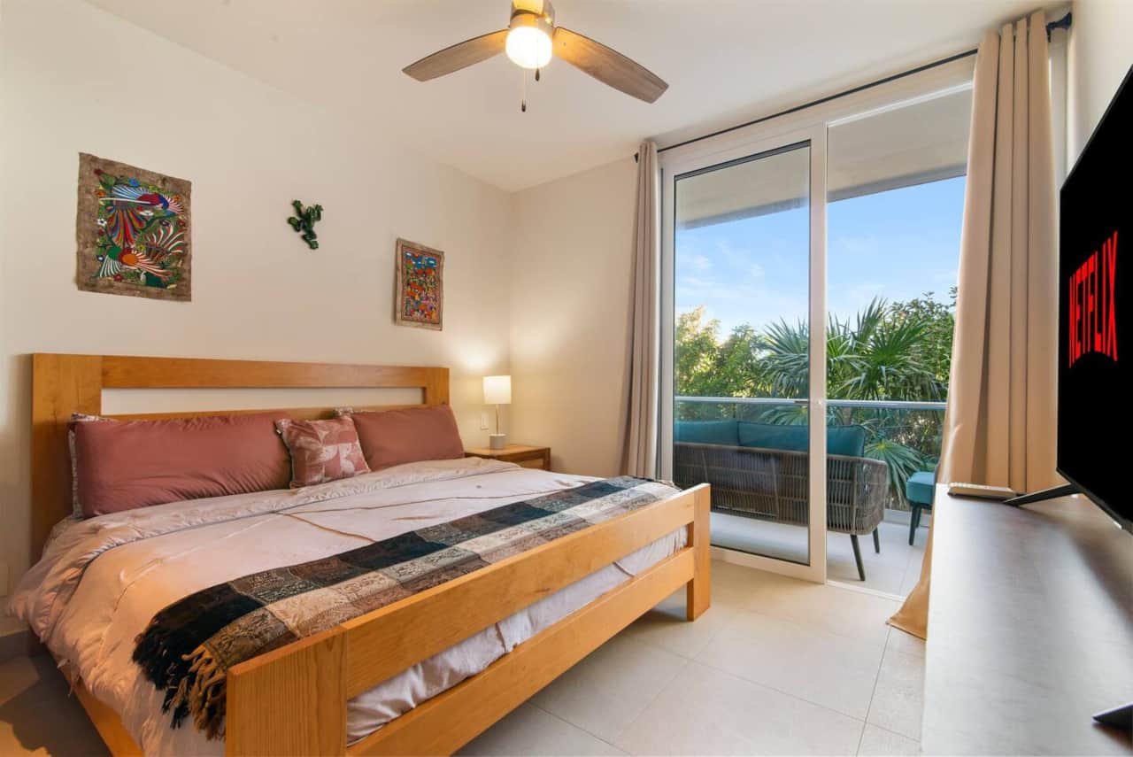 Unwind in the master bedroom with a king bed, AC, TV, and balcony.