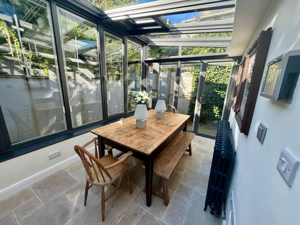Spacious dining area with large rustic wooden table and vintage bifold doors