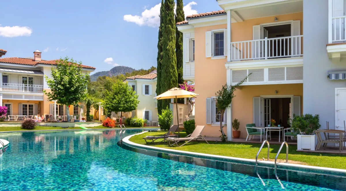 Exterior view of Portville B2 005 with a swimming pool, garden, and lounge chairs in Göcek.