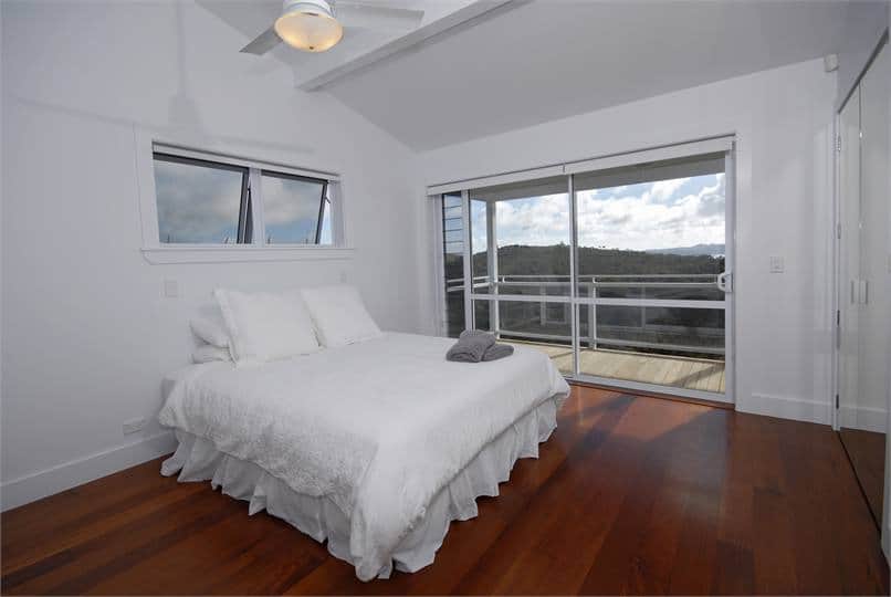 Master bedroom with queen bed, and views over the Bay of Islands at Wharau Lodge, Kerikeri.
