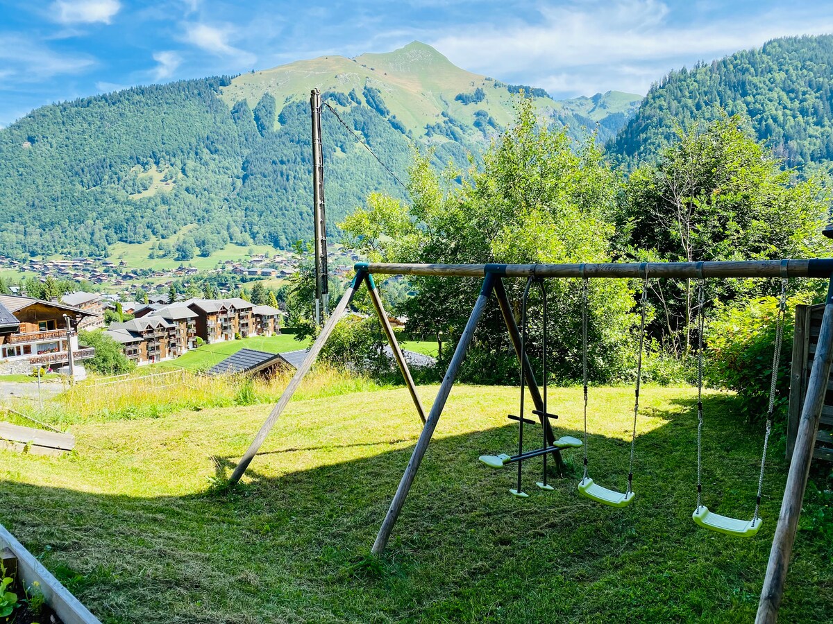 Jardin avec balançoires face aux montagnes