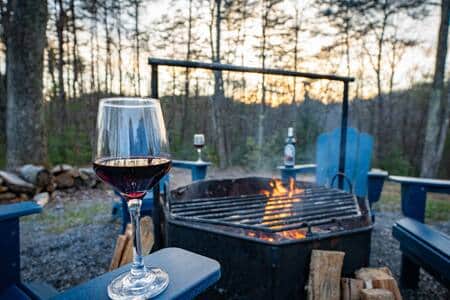 Fire pit in the backyard with grilling attachment and Adirondack chairs.  We provide the firewood!