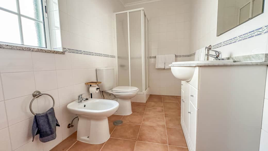 The bathroom has a shower, bidet, and vanity. The bathroom has a shower, bidet, and vanity.