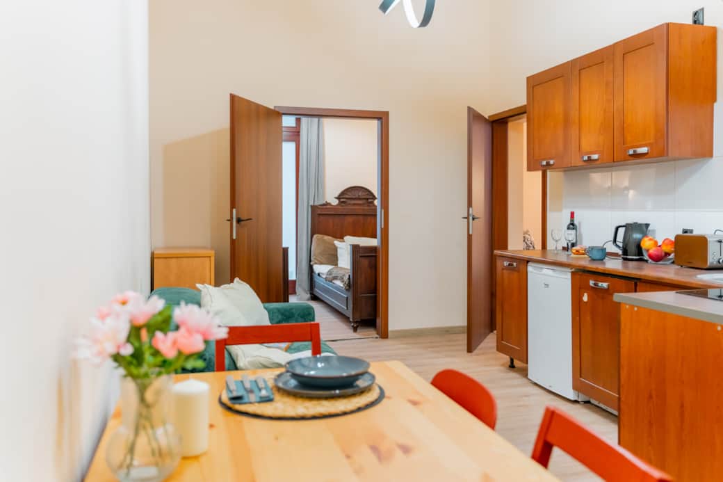 Jasna część dzienna z kuchnią i stołem jadalnianym w przytulnym, funkcjonalnym stylu.